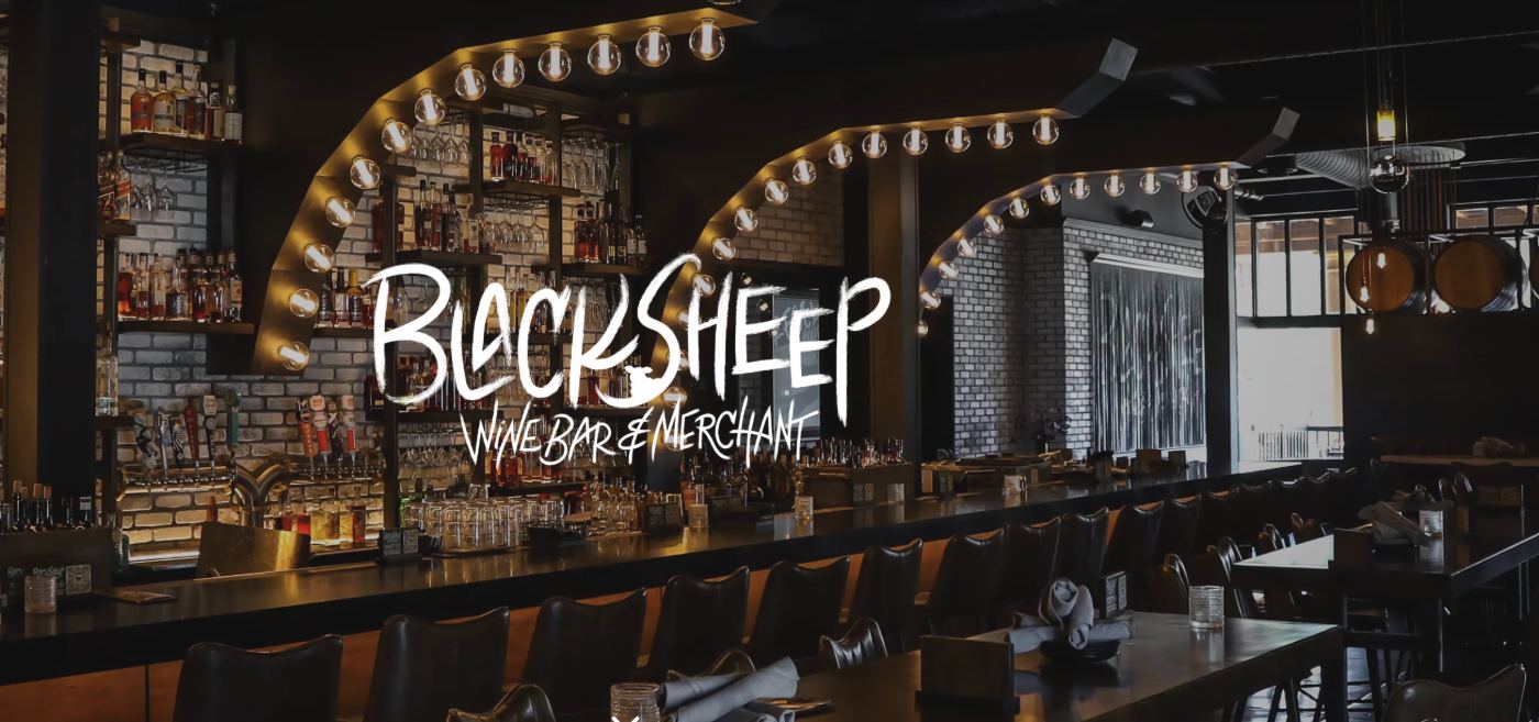 Black Sheep Wine Bar & Merchant interior with lit archways and bar