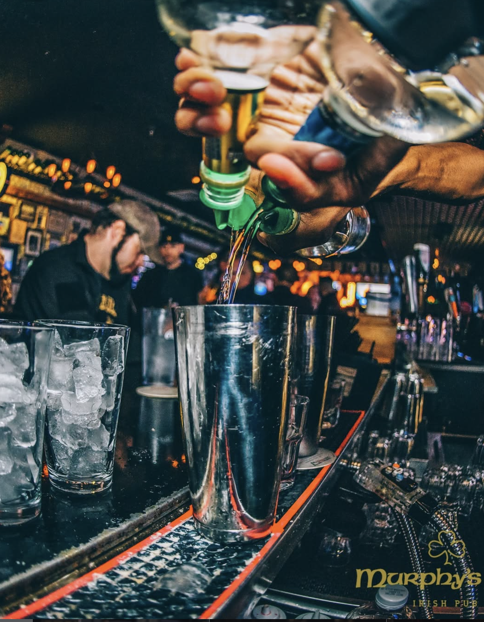 Bartender mid-pour over a shaker tin at Murphy’s Law Irish Pub